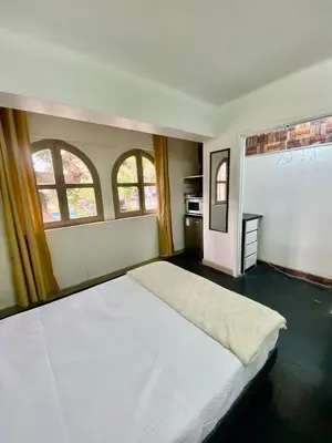a bedroom with a white bed and two windows at Amplia habitación dos camas dobles Miraflores in Lima