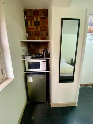 a microwave sitting on a shelf next to a mirror at Amplia habitación dos camas dobles Miraflores in Lima