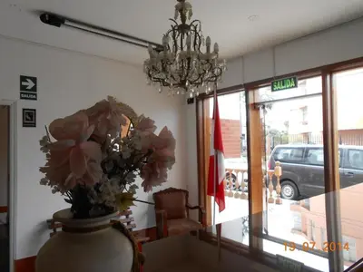 a vase with flowers on a table in front of a store at Hostal Cesar Alberto in Lima