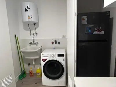 a kitchen with a washing machine and a black refrigerator at Brand new apartment in Miraflores in Lima