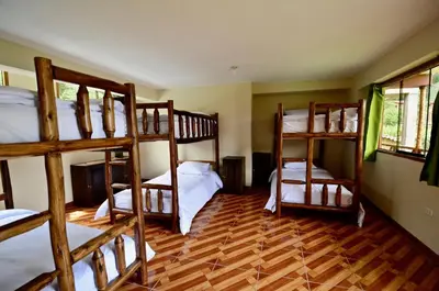 a room with four bunk beds in a house at KinsaPacha in Urubamba