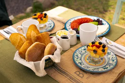 a table with plates of bread and fruit on it at KinsaPacha in Urubamba