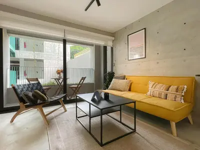 a living room with a yellow couch and a table at Barranco Breeze Loft Apartments by Geko in Lima