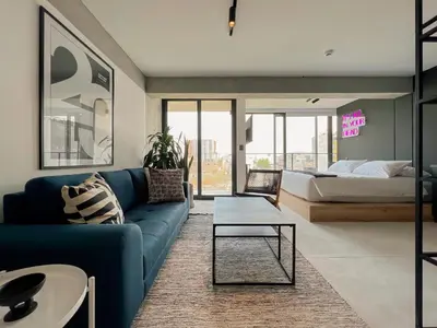 a living room with a blue couch and a bed at Barranco Breeze Loft Apartments by Geko in Lima