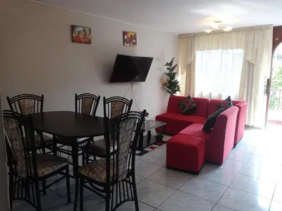 a living room with a red couch and a table at Modern Apartmen Furnished in Lima Near the Airport in Lima