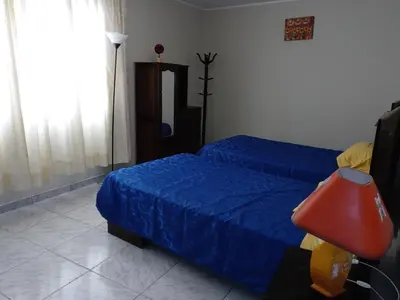 a bedroom with two beds and a red lamp at Modern Apartmen Furnished in Lima Near the Airport in Lima