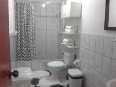 a small bathroom with a toilet and a shower at Modern Apartmen Furnished in Lima Near the Airport in Lima