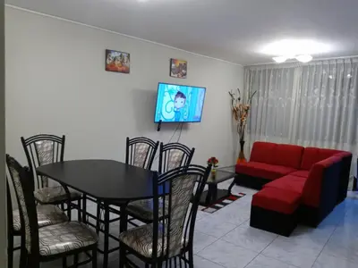 a living room with a table and a red couch at Modern Apartmen Furnished in Lima Near the Airport in Lima
