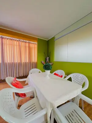 a dining room with a white table and chairs at Departamento completo cerca de la Plaza ,cocina equipada y vista a la ciudad in Ayacucho