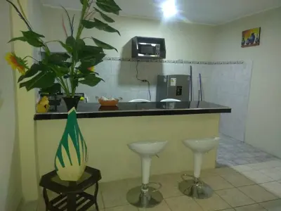 a kitchen with a counter with a sink and two stools at Angelica's House - Apartments Lima - Near the Airport in Lima