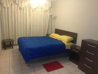 a bedroom with a bed with a blue blanket and yellow pillows at Angelica's House - Apartments Lima - Near the Airport in Lima