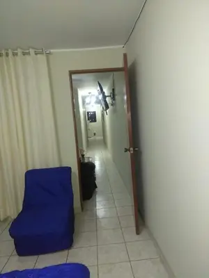 a room with a blue chair and a hallway at Angelica's House - Apartments Lima - Near the Airport in Lima