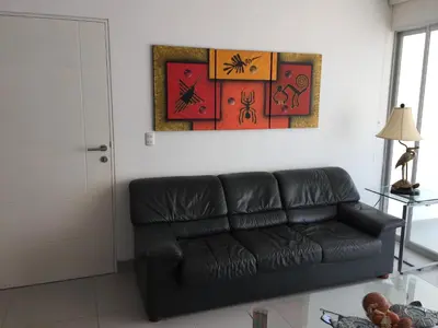 a living room with a black leather couch at Paracas Beach Vacation Rentals in Paracas