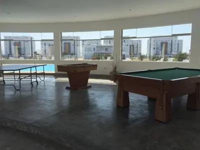 two pool tables in a room with a view of a city at Paracas Beach Vacation Rentals in Paracas