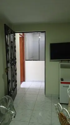 a room with a door open to a room with a television at Studio with kitchen and Bathroom Near The Airport in Lima