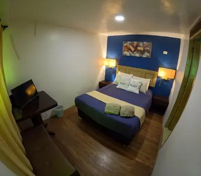 a hotel room with a bed and two lamps at Hotel Panaka II in Cusco