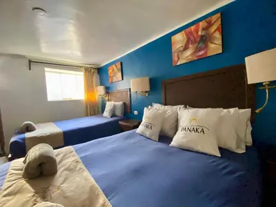 a hotel room with two beds with blue walls at Hotel Panaka II in Cusco