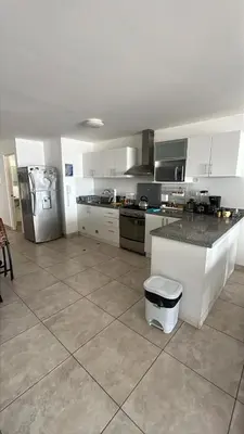 a kitchen with white cabinets and a stainless steel refrigerator at Comfortable duplex - Punta Hermosa in Punta Hermosa