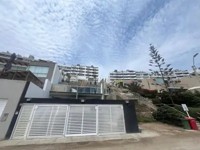 a white building with a blue sky in the background at Comfortable duplex - Punta Hermosa in Punta Hermosa