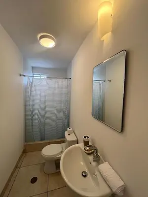 a bathroom with a sink and a toilet and a mirror at Comfortable duplex - Punta Hermosa in Punta Hermosa
