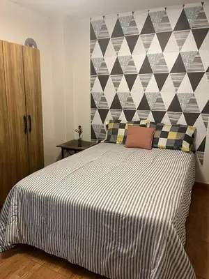 a bedroom with a bed with a black and white comforter at Minidepa Ecléctico in Lima