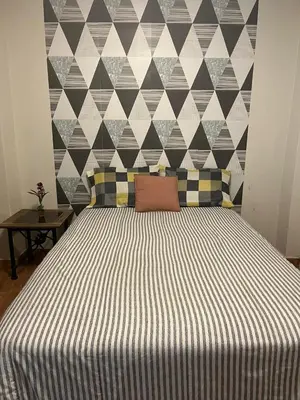 a bedroom with a large bed with a tiled wall at Minidepa Ecléctico in Lima