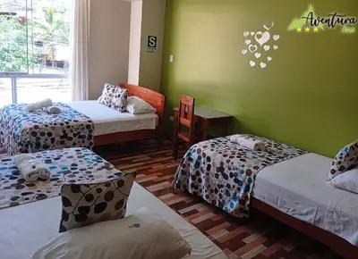 three beds in a room with green walls at Destino Aventura Peru in La Merced