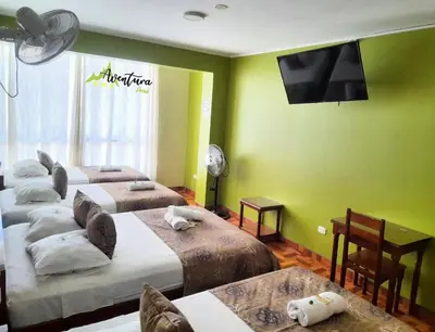 a room with four beds and a flat screen tv at Destino Aventura Peru in La Merced