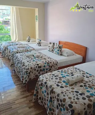 a row of four beds in a room at Destino Aventura Peru in La Merced
