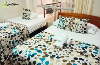 two beds in a hotel room with towels on them at Destino Aventura Peru in La Merced