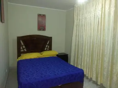 a bedroom with a bed with a blue blanket and yellow pillows at New Apartment furnished in Lima - Near the Airport in Lima