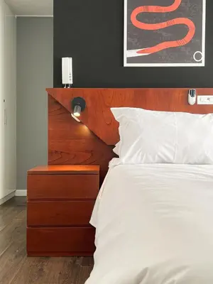 a bedroom with a white bed with a wooden headboard at The Snake 1BR by Geko in Lima