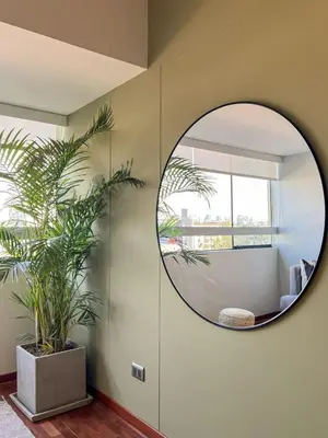 a circular mirror in a room with a plant at Coco 3BR by Geko in Lima