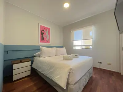 a bedroom with a large white bed with a window at Coco 3BR by Geko in Lima