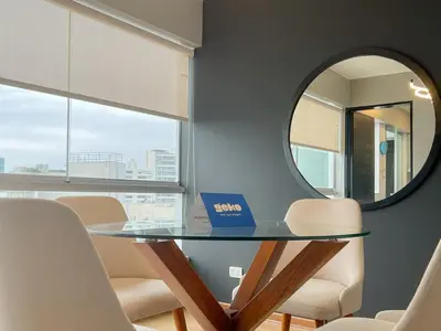 a dining room with a glass table and a mirror at Barranco Sailor Apartment by Geko in Lima