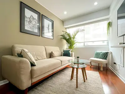 a living room with a couch and a table at The Bird 2BR by Geko in Lima