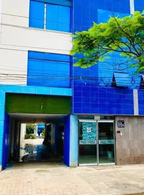 a blue building with a parking garage in front of it at Hostal Skyblue in Asia