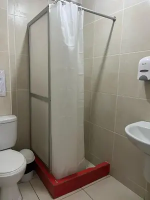 a bathroom with a shower with a toilet and a sink at Hostal Skyblue in Asia