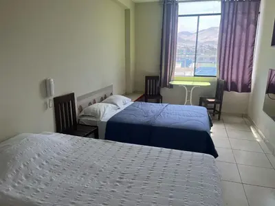 a hotel room with two beds and a window at Hostal Skyblue in Asia