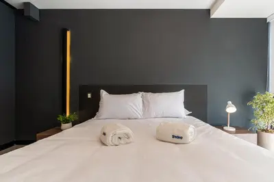 a large white bed with two towels on it at Rivera Navarrete by Geko in Lima