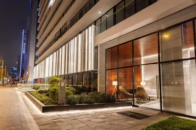 a building at night with a bench in front of it at Rivera Navarrete by Geko in Lima