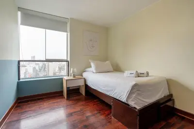 a small bedroom with a bed and a window at Caoba 3BR by Geko in Lima