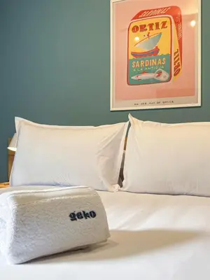 a bed with white pillows and a picture on the wall at Wood House 3BR by Geko in Lima