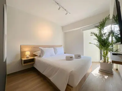 a bedroom with a large white bed and a window at Syberia 2BR by Geko in Lima