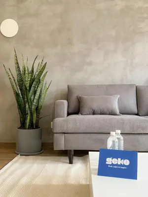 a gray couch in a living room with a plant at Syberia 2BR by Geko in Lima