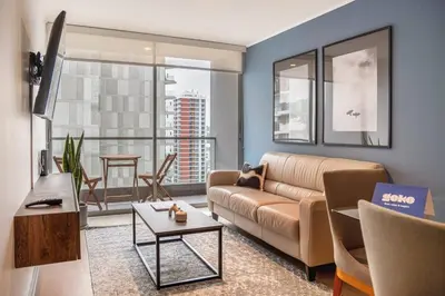 a living room with a couch and a table at Midnight District Apartment by Geko in Lima