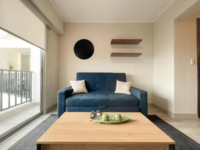 a living room with a blue couch and a table at Studio 4 by Geko in Lima