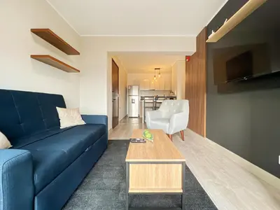 a living room with a blue couch and a table at Studio 4 by Geko in Lima