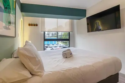 a large white bed with a small bag on it at Studio 4 by Geko in Lima