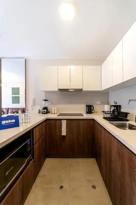 a kitchen with wooden cabinets and white appliances at Studio 4 by Geko in Lima